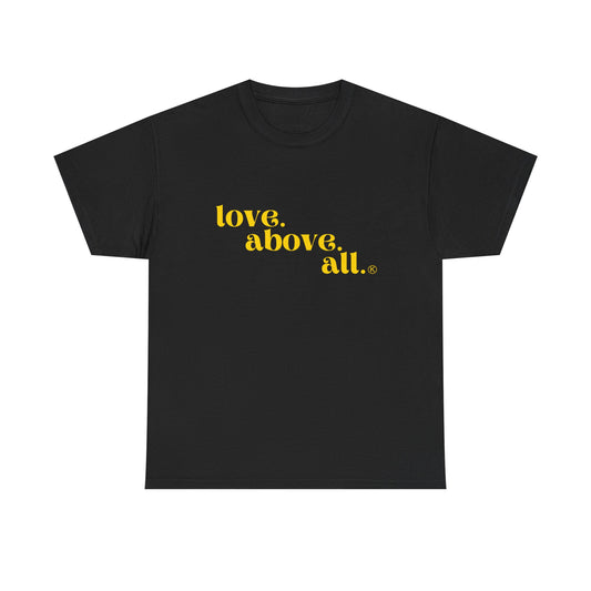 Black t-shirt with yellow text 'love. above. all.' on a white background